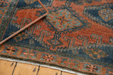Distressed Veece rug detail with low pile, exposed knot heads, and geometric patterns in teal and burnt orange.