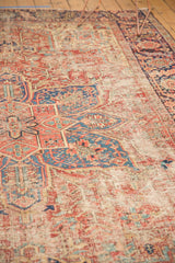 Intricate geometric patterns on a vintage Heriz rug, with visible localized foundation wear.