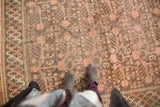 Vintage Distressed Khotan carpet featuring dusty pink pomegranate motifs, mostly even wear, and braided border.
