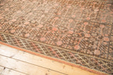 Distressed vintage Samarkand Khotan carpet, showing mostly even wear on pink pomegranate motifs and braided border.