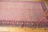 Distressed pink pomegranate motifs and charcoal geometric border on a vintage Khotan runner.