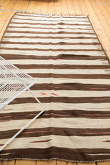Ivory and chocolate brown striped pattern of a vintage Turkish Kilim, with subtle red striations.