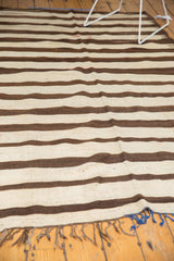 Hand woven vintage Turkish Kilim carpet fringe with dark brown and bright blue tassels.