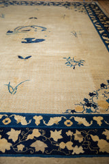 Ivory field of an antique Peking carpet with intricate lattice and cobalt blue scrolling border.