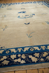 Worn ivory field with subtle blue lattice and navy border detail of an antique Peking carpet.