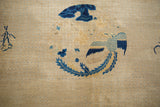 Worn beige field of antique Peking carpet, revealing subtle lattice and faded cobalt blue pattern.