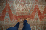 Distressed vintage Veece carpet, with faded brick red and seafoam green geometric patterns.