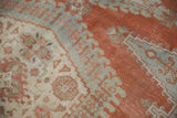 Geometric motifs in faded brick red, antique ivory, and seafoam green with low, distressed pile.