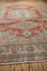 Distressed Persian Veece carpet texture with faded brick red, seafoam green patterns and fringe.