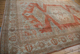 Faded brick red and seafoam geometric border on distressed Veece carpet with fringe.