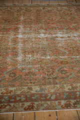 Distressed vintage Malayer carpet, showcasing herati motifs in faded blush rose and pale seafoam green.