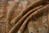 Distressed vintage Malayer carpet with faded blush rose herati pattern and worn border detail.