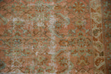 Distressed Malayer carpet detail: faded rose, green herati motif, and low pile texture.