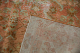 Distressed Malayer rug showing worn blush rose herati pile and woven beige foundation.