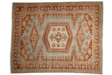 Distressed vintage Veece carpet with a geometric terra cotta rust medallion on a slate powder blue background.