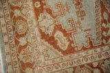 Distressed texture and low pile of a vintage Veece carpet with terracotta rust geometric details.