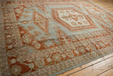 Angled perspective of a distressed Veece carpet highlighting its elongated rust medallion and slate blue field.