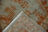 Folded corner of a distressed Veece carpet showing the hand-knotted foundation and low pile.