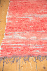 Moroccan runner's faded cherry red thick pile and grey fringe with subtle wefting.