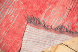 Thick faded cherry red pile, gray fringe, and upcycled rag fiber foundation of a Moroccan runner.