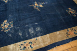Vintage Peking rug corner: dark indigo field, beige border, floral vinery, showing wear.
