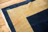Fringe, indigo border, and beige field on vintage Peking rug with wear.