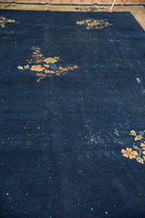 Vintage Peking carpet's dark indigo field with visible wear and light scattered marks.