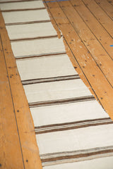 Horizontal ivory and brown striped hand woven Turkish Kilim with frayed cut line.