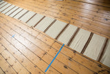 Frayed cut line along the edge of the striped vintage Turkish Kilim runner.