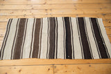 Vintage Turkish Kilim's hand woven texture with varying ivory, coffee, and charcoal brown stripes.