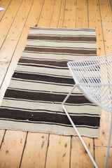 Horizontal stripes of varying thickness in ivory and brown shades on a Turkish Kilim.