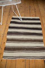 Geometric hand-woven vintage Turkish Kilim with rhythmic ivory and brown stripes.