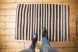 Charcoal brown and ivory striped bands on a hand woven Turkish Kilim rug.