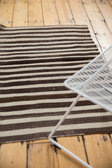 Hand woven vintage Turkish Kilim rug detail, showing horizontal brown and ivory banded stripes.