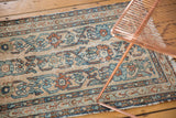 Distressed antique Lilihan runner detail, with faded beige, blue, and red floral texture.
