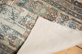 Corner of antique distressed Lilihan runner showing linen mounting, worn pile, and faded floral design.