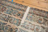 Linen-mounted fragmented section of an antique Lilihan rug, revealing worn floral vinery.