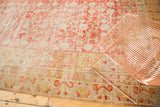 Khotan border detail: faded cinnabar red, gold, ivory, curvilinear design, showing even wear.