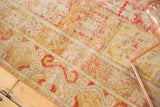 Distressed Khotan rug: faded cinnabar, gold, ivory, and stemmed pomegranate motifs.