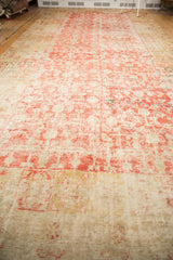 Antique distressed Khotan carpet texture with faded cinnabar red and ivory tones.