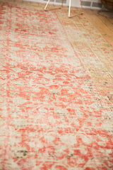 Close texture detail of distressed antique Khotan carpet with faded cinnabar red abrashes.