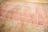 Distressed texture of a Khotan rug with faded cinnabar, ivory, and pomegranate motif.