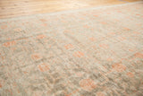Even wear revealing stemmed pomegranate motifs in terra cotta blush on antique Khotan rug.