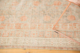 Distressed texture of antique Khotan rug, showing faded terra cotta pomegranate motifs and foundation.