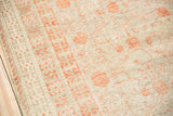 Distressed texture and terra cotta blush pomegranate motifs on an antique Khotan rug.