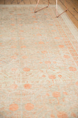Close-up of distressed Khotan rug, showing foundation through muted terra cotta pomegranate motifs.