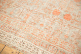 Distressed Khotan rug showing muted platinum and terra cotta stemmed pomegranate motifs.