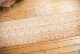 Textured distressed Khotan runner with ivory and pale cinnabar pomegranate motifs.