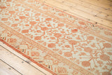 Vintage distressed Khotan runner with ivory field, pale cinnabar pomegranate motif, and soft wear.