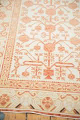 Decorative border of vintage Khotan runner next to faded ivory field with pomegranate motifs.